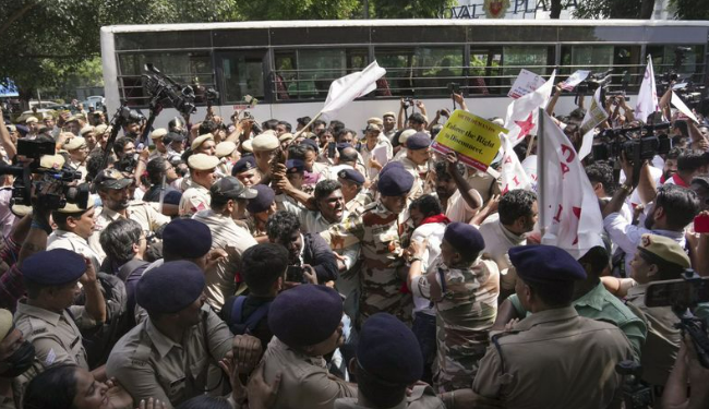 Police personnel amid a crowd of protesters in Delhi